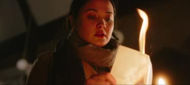 A young woman burns a piece of paper