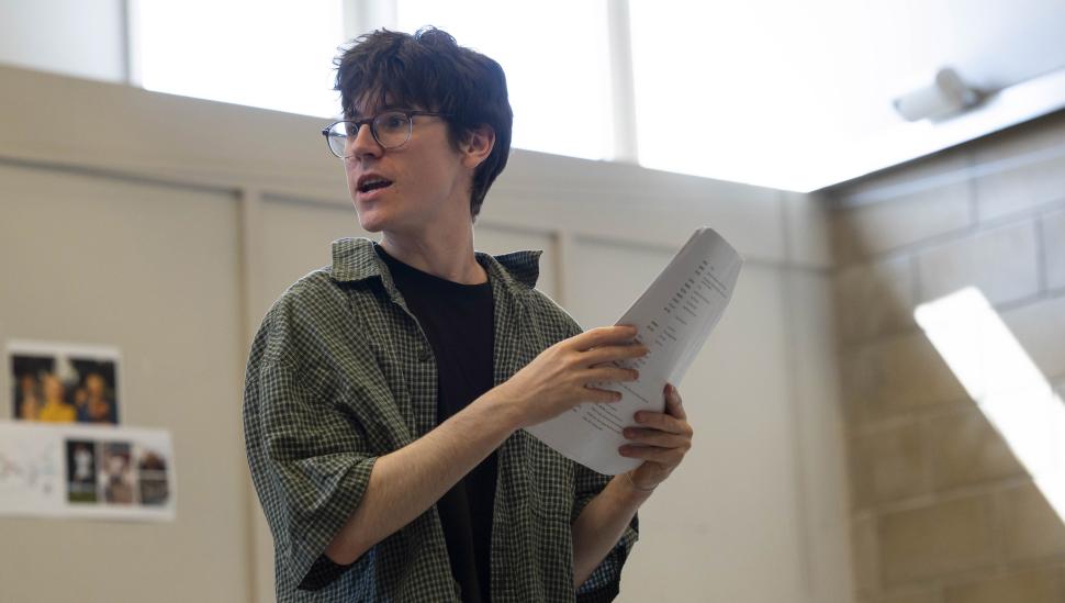 A student holding a script